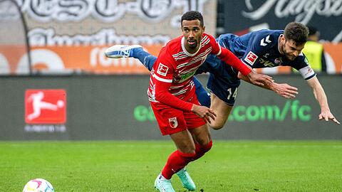 Augsburgs Noah Sarenren Bazee (l) und Kölns Jonas Hector liefern sich einen Zweikampf.