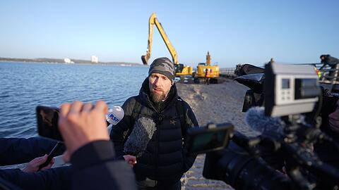 Robert Marc Lehmann spricht mit den Medien am Strand, in dessen N&auml;he der gestrandete Buckelwal im Wasser gelegen hatte.