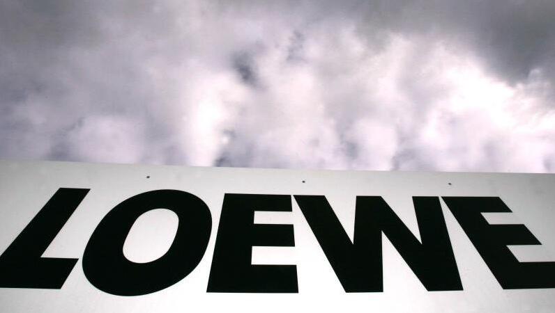 Das Loewe-Firmenlogo hängt vor dem bewölkten Himmel am Zaun des Betriebsgeländes in Kronach. Das Loewe-Firmenlogo hängt vor dem bewölkten Himmel am Zaun des Betriebsgeländes in Kronach.