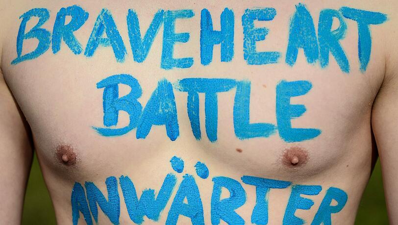 Ein Teilnehmer trägt den Schriftzug «Braveheart-Battle Anwärter» auf der Brust. Ein Teilnehmer trägt den Schriftzug «Braveheart-Battle Anwärter» auf der Brust.