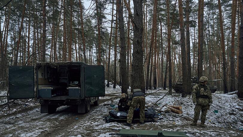 Militärsanitäter legen die Leiche eines in einem Gefecht in Kremenna getöteten Soldaten in einen Leichensack.