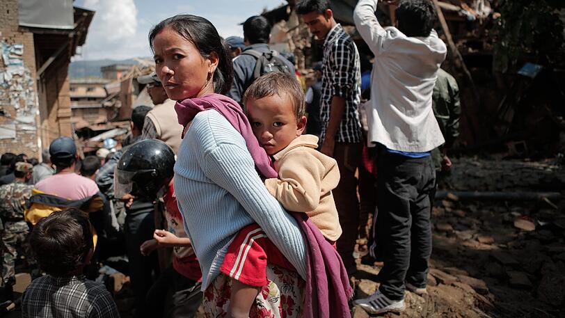 Im Kathmandu-Tal steht eine Mutter mit ihrem Kind inmitten der Zerstörung &ndash; das Erdbeben in Nepal im Jahr 2015 hat viele Deutsche spenden lassen. Eine derartige Katastrophe hat es 2016 nicht gegeben.