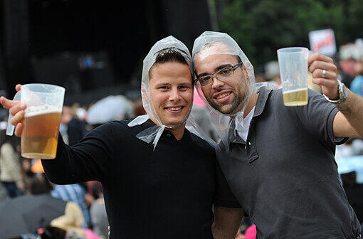 Wenn's außen nass ist, dann soll es auch innen nicht trocken sein: Diese Fans halten sich mit einem Bier bei Laune.