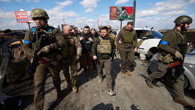Wolodymyr Selenskyj (m.) besucht Butscha. Nach Bekanntwerden eines Massakers an Zivilisten ist der ukrainische Präsident in die zerstörte Stadt gereist.