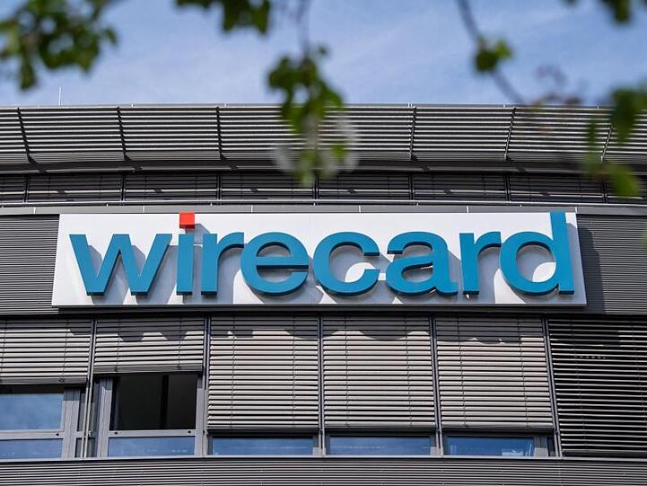 Schriftzug von Wirecard hängt an einem Gebäude. Foto: Peter Kneffel/Archivbild