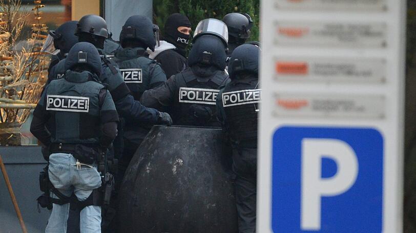 Mit erhobenen Händen kommt ein Mann auf die SEK-Beamten zu, im Hintergrund lauern Heckenschützen der Polizei. Die Beamten nehmen den Mann fest, es ist aber nicht der Täter, der sich in einem Imbiss in Freiburg veschanzt hat.