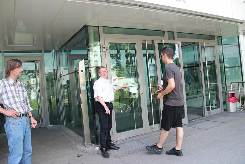 Leute warten vor dem KVR Gebäude.