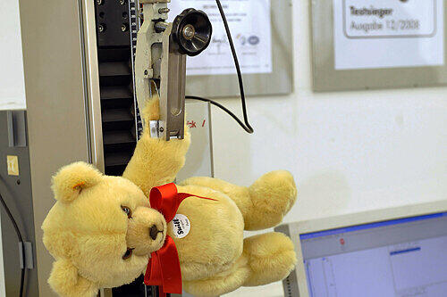 Ein Teddybär wird hier auf seine Belastbarkeit getestet.