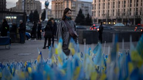 Eine Frau betrachtet die ukrainischen Flaggen, die zum Gedenken an die Gefallenen des Krieges in der Nähe des Kiewer Maidan-Platzes aufgestellt wurden.