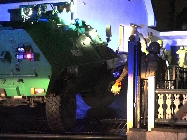 Ein gepanzertes Polizeifahrzeug steht in der Einfahrt zu einem Haus in Dortmund.