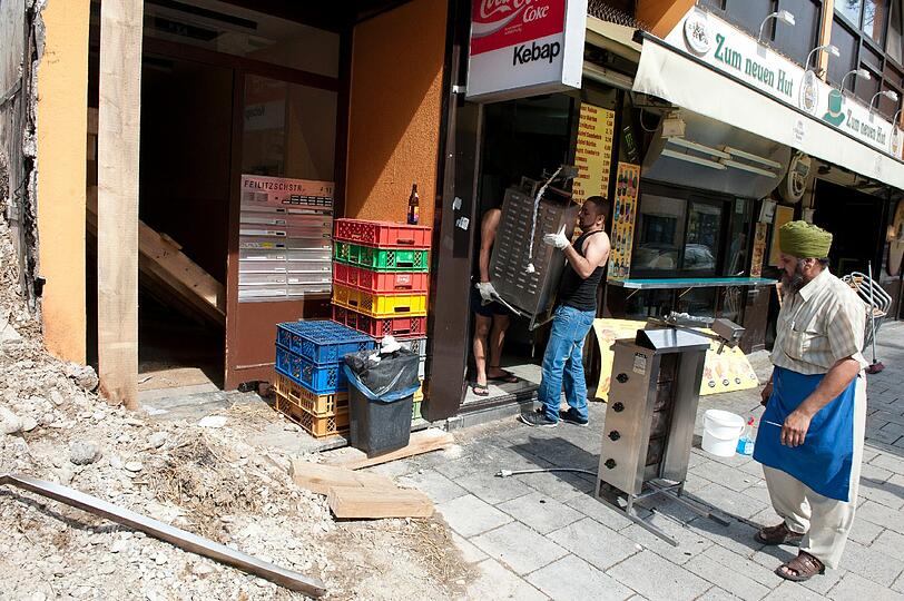 Was ist noch zu retten aus dem Imbiss-Laden? Mitarbeiter tragen Einrichtungsstücke ins Freie.