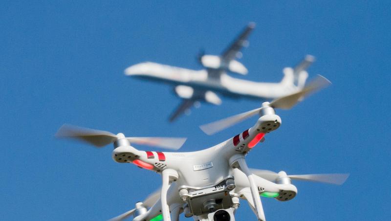 Eine private Drohne fliegt über einem Garten, während sich in weiter Entfernung ein Flugzeug im Anflug auf den Flughafen Düsseldorf befindet. Eine private Drohne fliegt über einem Garten, während sich in weiter Entfernung ein Flugzeug im Anflug auf den Flughafen Düsseldorf befindet.
