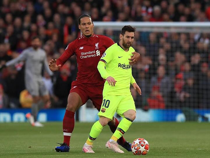 Virgil van Dijk (l) ist nah an Barcelonas Superstar Lionel Messi dran.