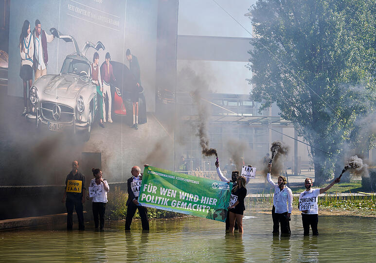 Aktivisten der Organisation "Extinction Rebellion" zünden am Rande der IAA Rauchfackeln.