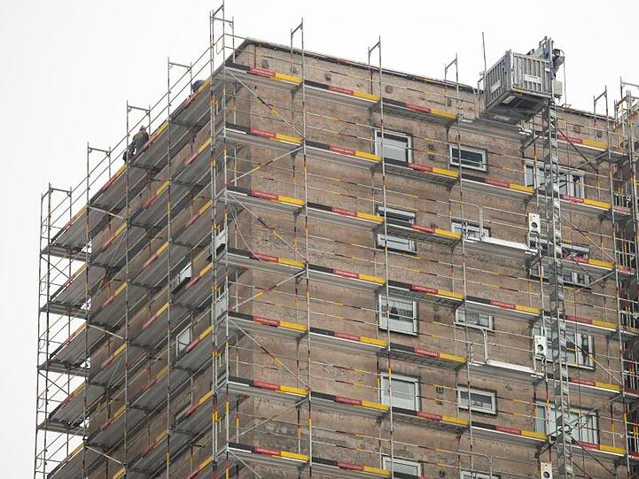 Baugerüste stehen an Hochhäusern im Stadtteil Langwasser, deren Fassaden renoviert werden. Foto: Daniel Karmann/Archiv