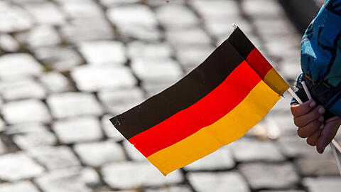 Ein Kind hält eine Deutschlandflagge. In Mainz beginnt das Bürgerfest zum Tag der Deutschen Einheit.