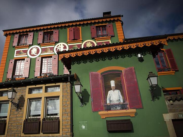 Ein Wandgemälde von Paul Bocuse schmückt die Fassade des Gourmet-Restaurants "L'Auberge du Pont de Collonges".