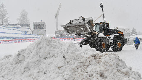 Ein Bagger bringt Schnee auf der Paul-Ausserleitner-Schanze weg.
