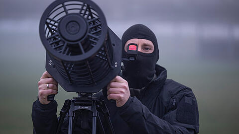 Ein Beamter eines SEK-Kommandos der Polizei simulieren die Bek&auml;mpfung einer Drohne. Mit einem Jammer nimmt er dabei das Flugger&auml;t am Himmel ins Visier. Das System k&ouml;nnte auch demn&auml;chst w&auml;hrend der Sicherheitskonferenz zum Einsatz kommen.