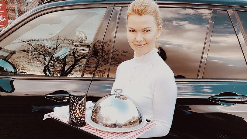 Sarah trägt das Essen vom Monti Monaco im Schlachthof auf den Parkplatz zum Auto.