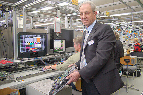 Das Fernseher-Herzstück in der Hand: Produktionschef Karl-Heinz Limbeck an der Fertigungsstraße für das Einstiegsmodell Axio.