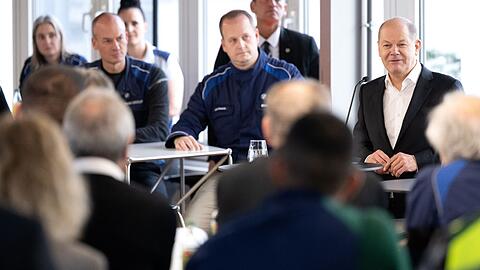 Bundeskanzler Olaf Scholz (r, SPD) spricht im BMW-Werk bei einem Besuch mit den Mitarbeitern.