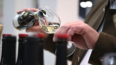 Ein Mitarbeiter des badischen Weinguts Bimmerle gie&szlig;t am Prowein-Messe-Stand seiner Firma Riesling in ein Glas.