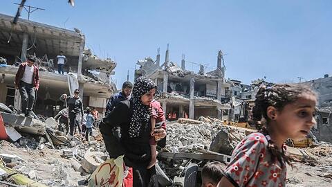 Einwohner des Gazastreifens gehen durch die Trümmer, die ein israelischer Luftangriff hinterlassen hat.
