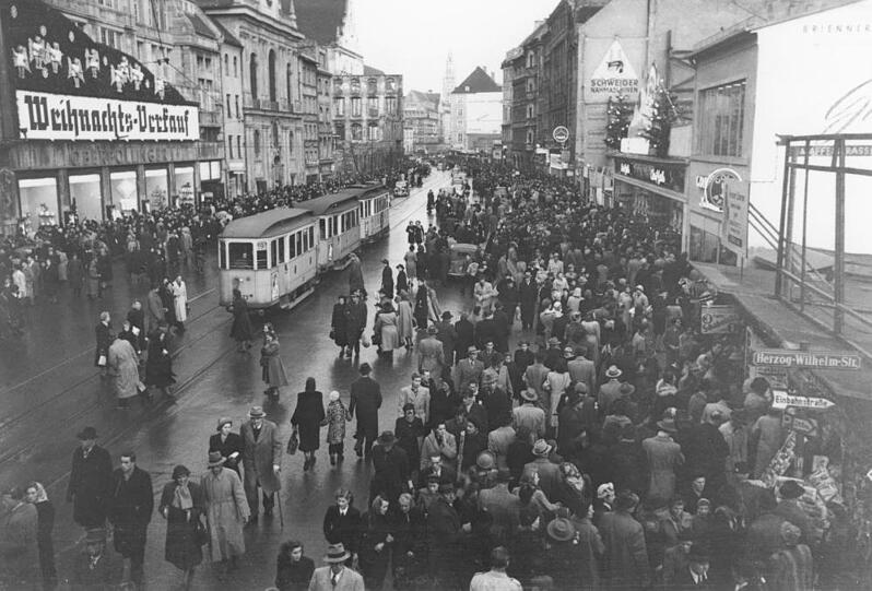 Weihnachts-Verkauf! Die von Behelfsbauten gesäumte Neuhauser Straße mit dem Karstadt Oberpollinger im adventlichen Trubel.