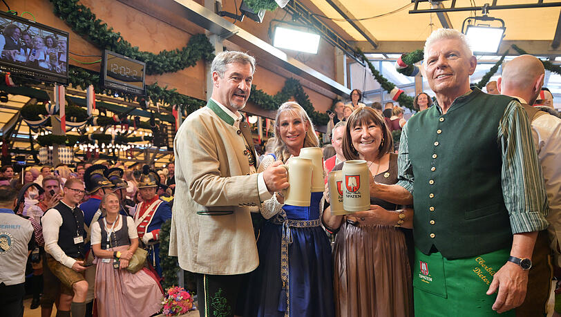 Markus Söder (CSU, l-r), Ministerpräsident von Bayern, mit seiner Frau Karin Baumüller-Söder, und Dieter Reiter (SPD, r), Oberbürgermeister von München, mit seiner Frau Petra, halten nach dem Anstich im Schottenhamel-Festzelt Bierkrüge. Markus Söder (CSU, l-r), Ministerpräsident von Bayern, mit seiner Frau Karin Baumüller-Söder, und Dieter Reiter (SPD, r), Oberbürgermeister von München, mit seiner Frau Petra, halten nach dem Anstich im Schottenhamel-Festzelt Bierkrüge.