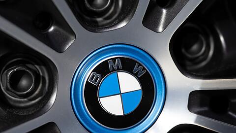 Das Logo von BMW ist an einer Felge von einem Auto zu sehen.