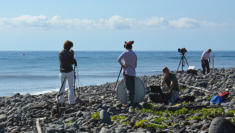 Filmcrews stehen an dem Ort auf der Insel La Réunion im indischen Ozean, wo das Wrackteil einer Boeing 777 angespült wurde.