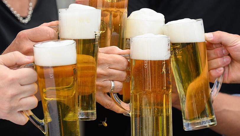 Eine Gesellschaft stößt mit Bier an.