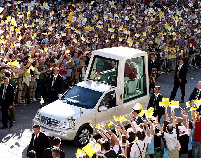 So auch 2006 in München: Papst Benedikt XVI winkt zu Beginn seines Besuches in Bayern bei einer Fahrt mit dem Papamobil zur Mariensäule wartenden Gläubigen zu.