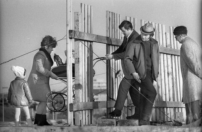 Weihnachten 1970: Diese Familie meistert die Absperrung an der Großbaustelle Olympiagelände mit vereinten Kräften.