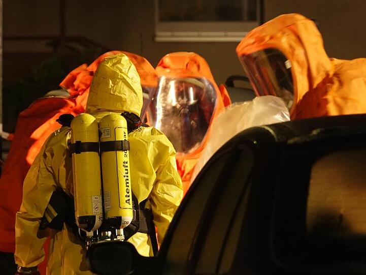 Feuerwehrleute sind in Schutzanzügen im Einsatz.