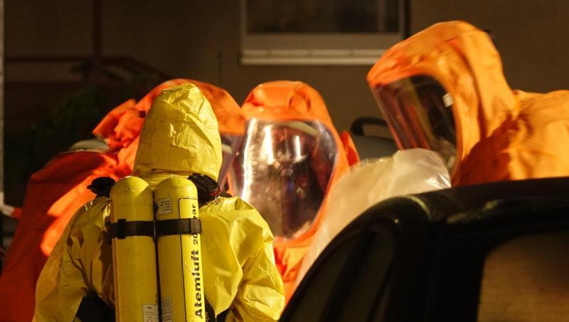 Feuerwehrleute sind in Schutzanzügen im Einsatz. Feuerwehrleute sind in Schutzanzügen im Einsatz.