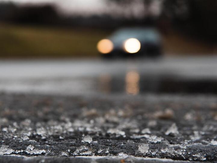 Eisreste sind am Rande einer Straße zu sehen.
