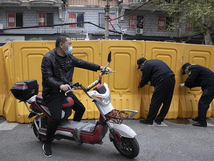 In der Stadt Wuhan werden Barrieren entfernt. Weil China offiziell kaum Neuinfektionen mit dem Coronavirus meldet, hebt es die Beschränkungen für die Bevölkerung allmählich auf.