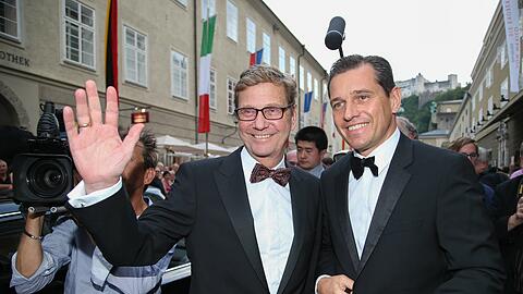 Zurück mit einem lachenden Gesicht: Ex-Außenminister Guido Westerwelle kommt mit seinem Partner Michael Mronz (r.) zur &bdquo;Fidelio&ldquo;-Premiere in Salzburg an und freut sich über die vielen Fans, die ihm zujubeln.