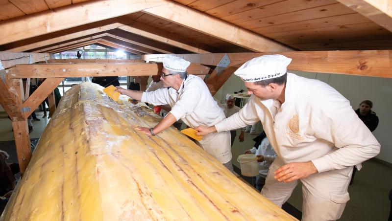 Bäcker der Schutzgemeinschaft Dresdner Stollen streichen Butter und Zucker auf den Riesenstollen. Bäcker der Schutzgemeinschaft Dresdner Stollen streichen Butter und Zucker auf den Riesenstollen.