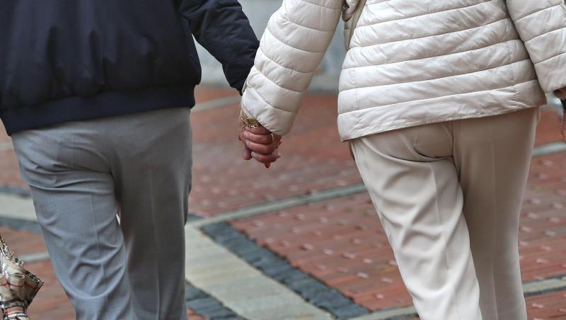 Ein älteres Paar Hand in Hand in einer Fußgängerzone. Ein älteres Paar Hand in Hand in einer Fußgängerzone.