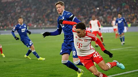 Hoffenheims Wout Weghorst und Münchens Jamal Musiala (r) kämpfen um den Ball.
