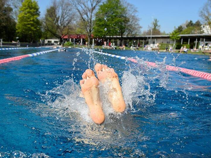 Füße einer Person schauen im Westbad in Nürnberg aus dem Wasser. Foto: Timm Schamberger/Archiv