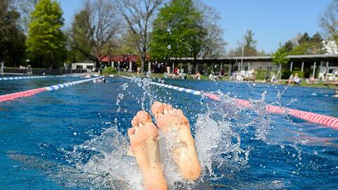 Füße einer Person schauen im Westbad in Nürnberg aus dem Wasser. Foto: Timm Schamberger/Archiv