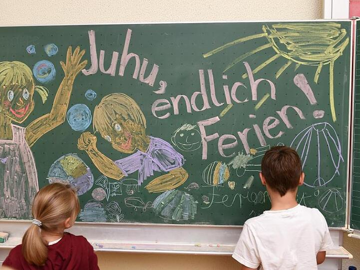 Erst- und Zweitklässler malen in der Grundschule ein Bild an die Tafel. Foto: Felix Kästle/Archiv