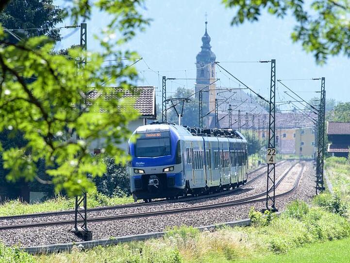 Ein Zug fährt über die Gleise der Bahntrasse durch das Inntal zwischen Rosenheim und Kufstein. Foto: Matthias Balk/dpa