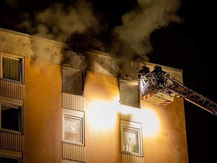 Feuerwehrleute sind mit einer Drehleiter im Einsatz.