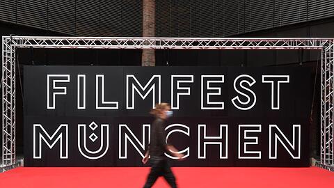 Eine Besucherin geht beim Internationalen Filmfest München im Festivalzentrum Gasteig am Roten Teppich vorbei.