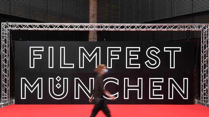 Eine Besucherin geht beim Internationalen Filmfest München im Festivalzentrum Gasteig am Roten Teppich vorbei.